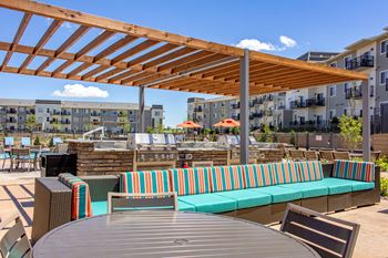 table, outdoor couch, and grills with a pergolaat SoRoc On Maine, Rochester